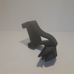 May include: A black plastic 3D printed object with a geometric design. The object has a curved shape and a flat base.