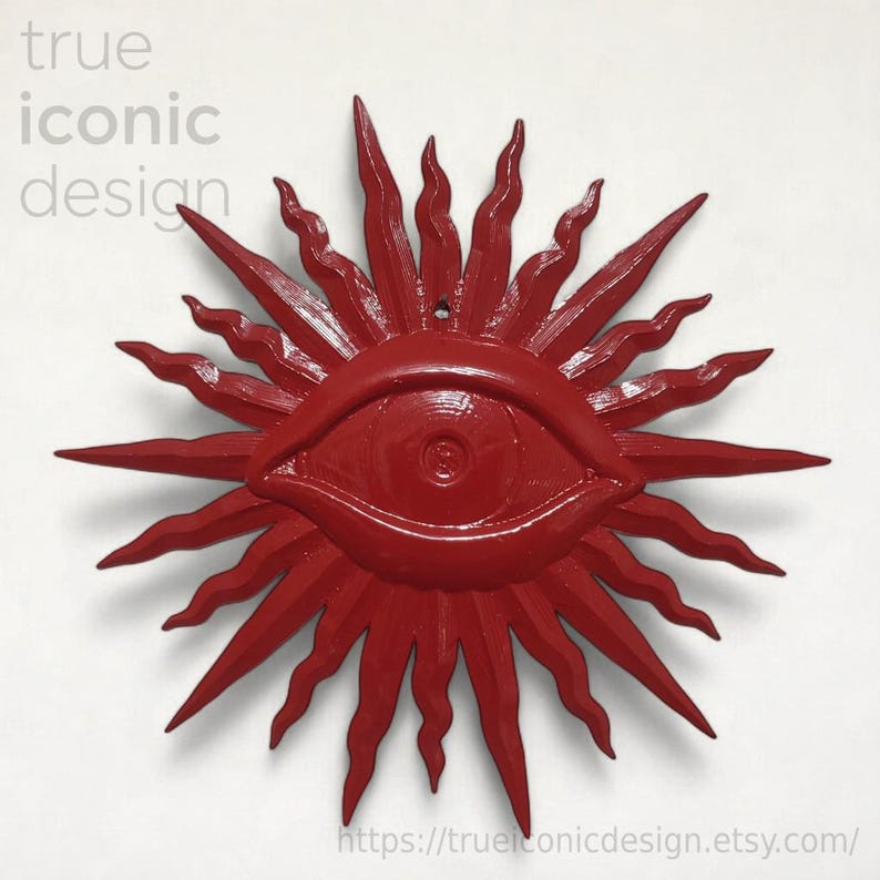 May include: A bright red wall decoration featuring a central eye motif surrounded by radiating, wavy sunburst rays. The text 'true iconic design' appears in the upper left corner, and the URL 'trueiconicdesign.etsy.com' is at the bottom.