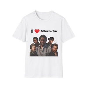 May include: White t-shirt featuring a group of men and the text "I ❤️ Arthur Morgan". The design includes a red heart symbol. The shirt is a crew neck style.