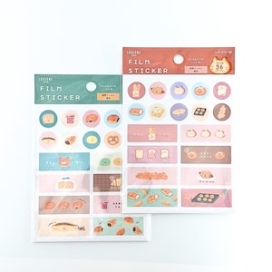 Puede incluir: Dos paquetes de pegatinas de película Loujene Tokyo con varias ilustraciones de pan y pasteles. El paquete izquierdo tiene un encabezado verde y el derecho un encabezado rojo con el texto 'FILM STICKER' y '36 pieces' impresos en el envase.