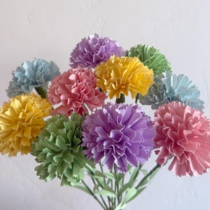 May include: A bouquet of paper carnations in various pastel colors, including yellow, green, pink, light blue, and purple.