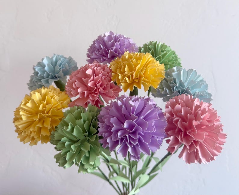 May include: A bouquet of paper carnations in various pastel colors, including yellow, green, pink, light blue, and purple.