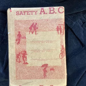 May include: Vintage "Safety A.B.C." book with a red and tan cover. The cover features illustrations of children and the text "SAFETY A.B.C." in red. The book has space for the title, pupil's name, and school.