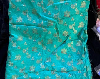 Beautiful turquoise sari silk woven with gold and pink threads. Has a beautiful border on one edge Fabric is 52 x 37. Raw edge on 3 sides.