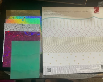 12x12 paper pad by Cosmo Cricket, 11 sheets 6x6 gold foil designs 6 silver holographic designs, 1 6x8 gold holographic and 12 Mylar sheets.