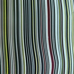 Op de afbeelding: Een close-up van een stapel kleurrijk, gestreept papier. Het papier is in een golvend patroon gerangschikt, waardoor een visueel interessante textuur ontstaat.