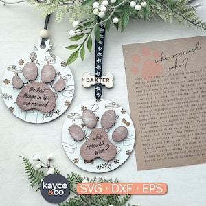 May include: Two wooden pet-themed ornaments with paw prints and text. One says "the best things in life are rescued" and "meow". The other says "who rescued who?" and "woof". A card with text about rescuing pets is also shown.