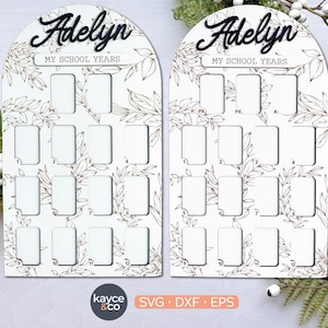 以下が含まれることがあります： 黒い筆記体で「Adelyn」と書かれた2つの白い木製のスクールイヤーボード。各ボードには花の模様があり、PKから12年生までの写真用のスペースがあります。「MY SCHOOL YEARS」というテキストも表示されています。