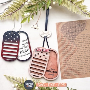 May include: Wooden dog tag ornaments with an American flag design in red, white, and blue. One tag reads "some never met their HERO I raised mine." Another says "Proud MILITARY Family."