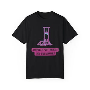 May include: Black t-shirt with a pink illustration of a guillotine and the text "Headrest for Tyrants and Billionaires".