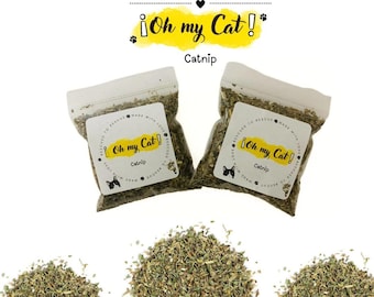 May include: Two small resealable bags filled with dried catnip, labeled "Oh my Cat! Catnip". The bags are on a white background with three piles of catnip scattered around them.
