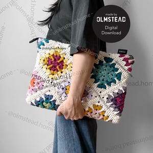 May include: A white crochet bag with colorful granny squares. The bag is made with a variety of colors, including pink, purple, teal, yellow, and green. The bag is held by a person wearing a black shirt and blue jeans. The text "made by OLMSTEAD Digital Download" is visible on the image.