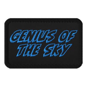Op de afbeelding: Zwarte geborduurde patch met blauwe tekst die "Genius of the Sky" luidt.