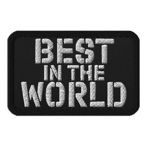 Könnte beinhalten: Schwarzer gestickter Aufnäher mit weißem Text, der "BEST IN THE WORLD" lautet.