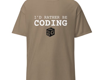 Può includere: T-shirt color cachi con la scritta bianca "I'D RATHER BE CODING" sopra una grafica a cubo in bianco e nero. La maglietta a maniche corte ha una vestibilità ampia, adatta all'uso quotidiano.