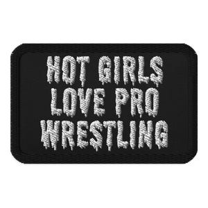 May include: Black rectangular patch with white embroidered text that reads "HOT GIRLS LOVE PRO WRESTLING". The patch has a black border and a textured appearance.