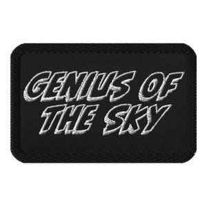 Op de afbeelding: Zwarte geborduurde patch met witte tekst die "Genius of the Sky" luidt.