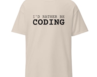 Può includere: Una maglietta beige con la scritta "I'd rather be coding" stampata in nero.