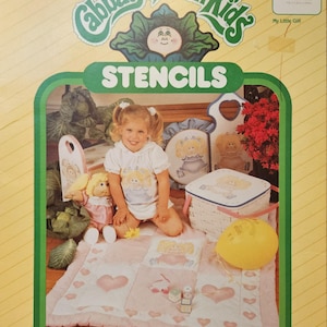 May include: A box of Cabbage Patch Kids stencils for home and fashion decor. The box features a girl holding a Cabbage Patch Kid doll. The stencils are made of Mylar and are pre-cut to 8.5 inches by 11 inches. There are four sheets of stencils in the box.