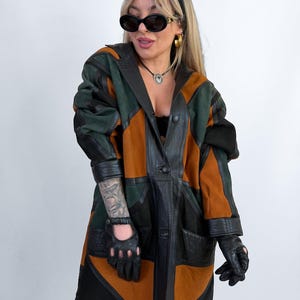 Casaco vintage patchwork em camurça e couro, estilo anos 80/90, com blocos de cores, em tons de laranja, verde e preto, oversized e avant-garde, tamanhos M-L.