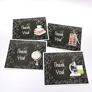 May include: Four black chalkboard-style thank you cards with white chalk drawings of school supplies. The cards feature the text "Thank You!" in white. The school supplies include a globe, a microscope, a paint palette, and a stack of books.