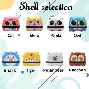 Puede incluir: Una colecci&oacute;n de ocho peque&ntilde;os sellos de pl&aacute;stico con tem&aacute;tica animal y el texto Shell selection. Los dise&ntilde;os incluyen un gato rosa, un Akita amarillo, un panda blanco y negro, un b&uacute;ho azul, un tibur&oacute;n azul, un tigre amarillo, un oso polar blanco y un mapache marr&oacute;n.