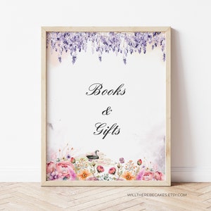 Op de afbeelding: Een ingelijst bord met de woorden "Books & Gifts" in elegant schrift. De bovenkant van het bord heeft een aquarel illustratie van paarse blauwe regen, en de onderkant heeft een bloemstuk met een zwaan op een vijver.
