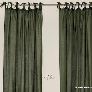 Puede incluir: Un par de cortinas de lino verde con la parte superior fruncida y lazos. Las cortinas están colgadas de una barra de metal.