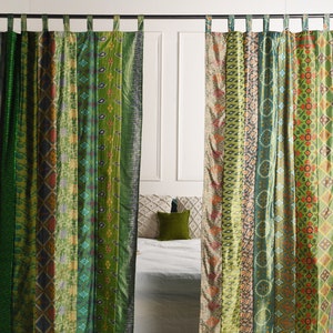 Puede incluir: Cortinas estampadas en verde y marrón con una cama blanca y almohadas en el fondo.