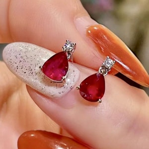 Pu&ograve; includere: Un paio di orecchini di rubino e diamanti. Gli orecchini sono a forma di goccia e presentano un'unica pietra di rubino con un piccolo accento di diamante.