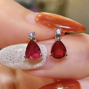Pu&ograve; includere: Un paio di orecchini di rubino e diamanti. Ogni orecchino presenta un rubino a forma di lacrima con un diamante pi&ugrave; piccolo sopra.