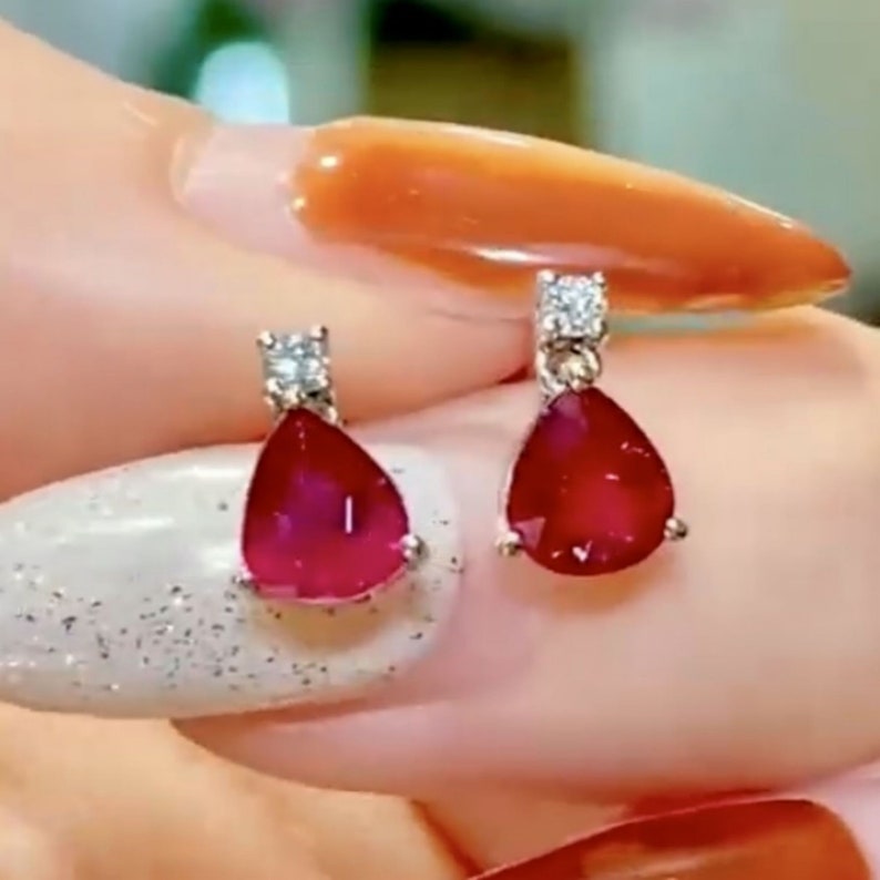 Pu&ograve; includere: Un paio di orecchini di rubino e diamanti. Ogni orecchino presenta un rubino a forma di lacrima con un solo accento di diamante.