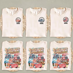 Puede incluir: Seis camisetas de color crema con diferentes dise&ntilde;os. La fila superior presenta peque&ntilde;os gr&aacute;ficos de coches dentro de un c&iacute;rculo a cuadros, con la palabra "NAME" debajo. La fila inferior tiene un gr&aacute;fico m&aacute;s grande con las palabras "RADIATOR SPRINGS" y varios coches de dibujos animados.