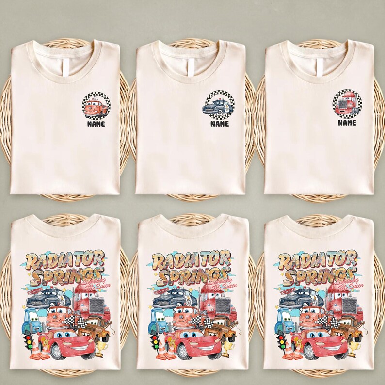 Puede incluir: Seis camisetas de color crema con diferentes dise&ntilde;os. La fila superior presenta peque&ntilde;os gr&aacute;ficos de coches dentro de un c&iacute;rculo a cuadros, con la palabra "NAME" debajo. La fila inferior tiene un gr&aacute;fico m&aacute;s grande con las palabras "RADIATOR SPRINGS" y varios coches de dibujos animados.