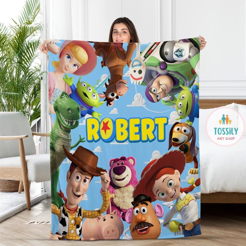 以下が含まれることがあります： ウッディ、バズ・ライトイヤー、ジェシー、レックスなど、トイ・ストーリーのキャラクターが描かれた青と黄色の毛布。毛布には「ROBERT」という名前が黄色い文字で星と一緒に印刷されています。
