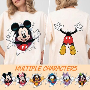 May include: A white ceramic mug with a black handle and the text "But First, Coffee" in a bold, black font. The mug is set against a blurred background, suggesting a cozy setting. The mug appears to be approximately 4 inches tall.