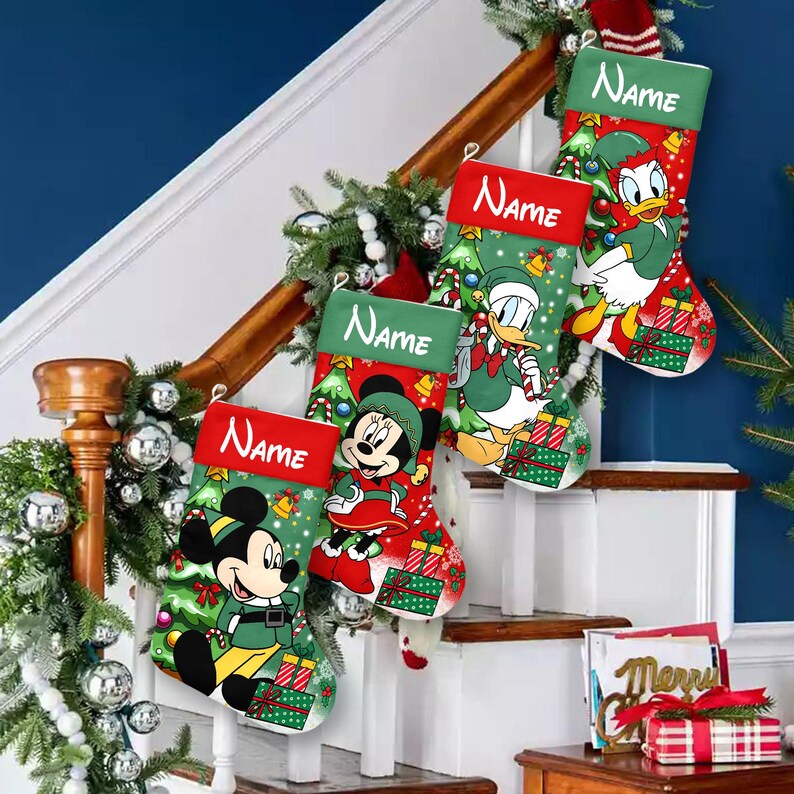 May include: Four Christmas stockings with Disney characters Mickey Mouse, Minnie Mouse, and Donald Duck. Each stocking has a red cuff with the word "Name" in white. The stockings are decorated with Christmas trees, presents, and bells. The stockings are hanging on a staircase.