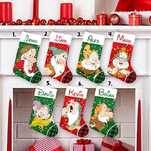 May include: Seven Christmas stockings with different dwarf characters from Snow White. Each stocking has a name on the top, including John, Liam, Alex, Mark, David, Kevin, and Brian. The stockings are red, green, and white.