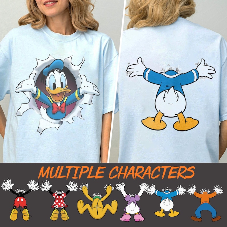 May include: Light blue t-shirt featuring a graphic of Donald Duck bursting through a torn hole, with the back of the shirt showing the same design. The shirt also has the text "MULTIPLE CHARACTERS" at the bottom, with cartoon character graphics.