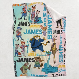 K&ouml;nnte beinhalten: Eine weiche, gefaltete Decke mit Cartoon-Figuren und dem Namen "JAMES" in verschiedenen Farben. Die Decke hat eine wei&szlig;e R&uuml;ckseite und ist mit Bildern von Tieren in einem farbenfrohen Design verziert.