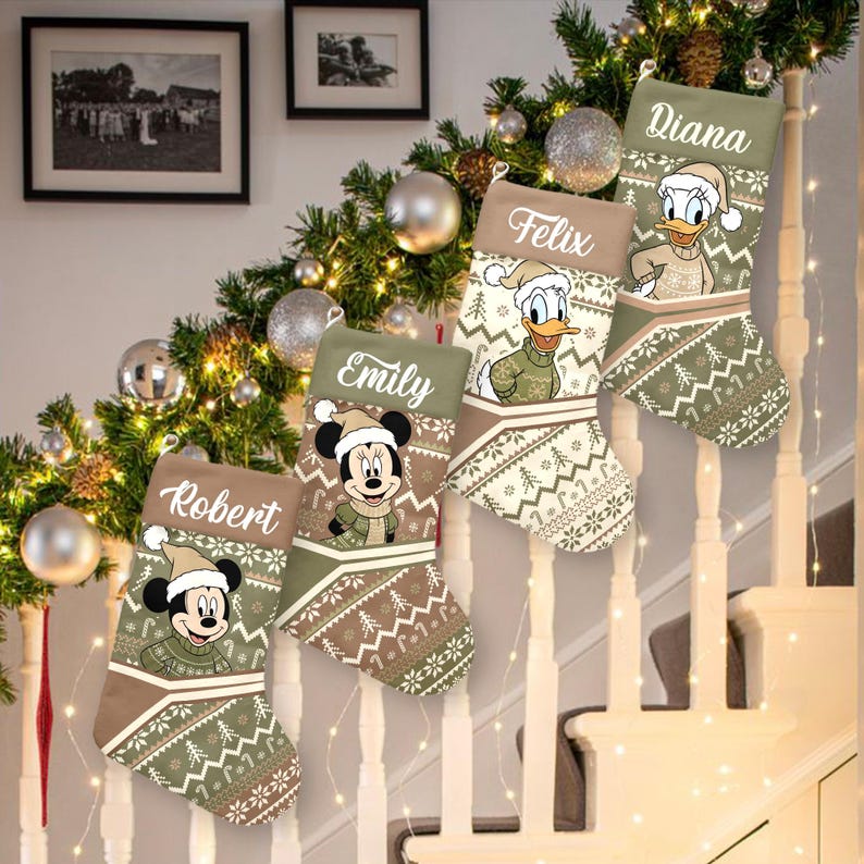 May include: Five Christmas stockings hang on a staircase, each with a different name: Robert, Emily, Felix, Diana. The stockings feature cartoon characters Mickey Mouse and Donald Duck, wearing winter attire. The stockings have a green and brown color scheme with a festive pattern.