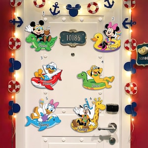 May include: A white door decorated with Disney character cutouts, including Mickey Mouse, Minnie Mouse, Donald Duck, Pluto, Daisy Duck, and Goofy, each on inflatable floats. Decorative anchors, life preservers, and Mickey Mouse silhouettes are also present.