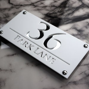 House Wall Plaques UK | Luxe A4 | Numéro Maison Elegant Acrylic Designs | Personnalisez Votre Maison Matt White & Silver Mirror 28cm x 14cm