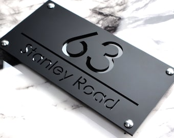 Könnte beinhalten: Schwarzes Acryl-Hausnummernschild mit der Nummer 63 und dem Straßennamen "Stanley Road" ausgeschnitten.