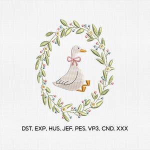 May include: An embroidered design of a white goose with a pink bow, encircled by a floral wreath of green leaves, white flowers, and blue and pink berries. The text "DST, EXP, HUS, JEF, PES, VP3, CND, XXX" is at the bottom.