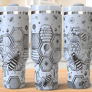 Könnte beinhalten: Weiße Edelstahl-Reisebecher mit einem schwarz-weißen Bienenwaben- und Bienenmuster. Der Becher hat einen Griff und einen Deckel. "Seamless Design" ist in der rechten unteren Ecke des Bildes aufgedruckt.