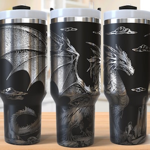 Puede incluir: Una taza de viaje de acero inoxidable negro con un diseño de dragón plateado. La taza tiene un asa y una tapa.