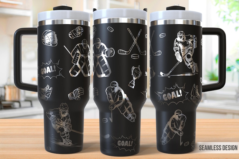 May include: Black stainless steel travel mug with a silver hockey player design. The mug has a handle and says "GOAL!" on the side.