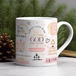 Op de afbeelding: Een witte keramische mok met een roze en gouden ontwerp. De mok heeft verschillende inspirerende citaten en zinnen, waaronder "Trust in His Promises", "God is My Anchor", "Feeling Blessed" en "Pray Believe Receive".