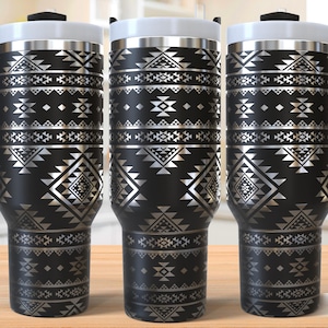 May include: Three stainless steel travel mugs with black and silver geometric patterns. The mugs have lids and handles.
